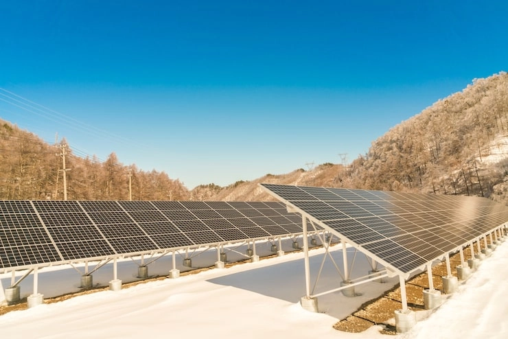 Solar panels in a snowy landscape under a clear blue sky