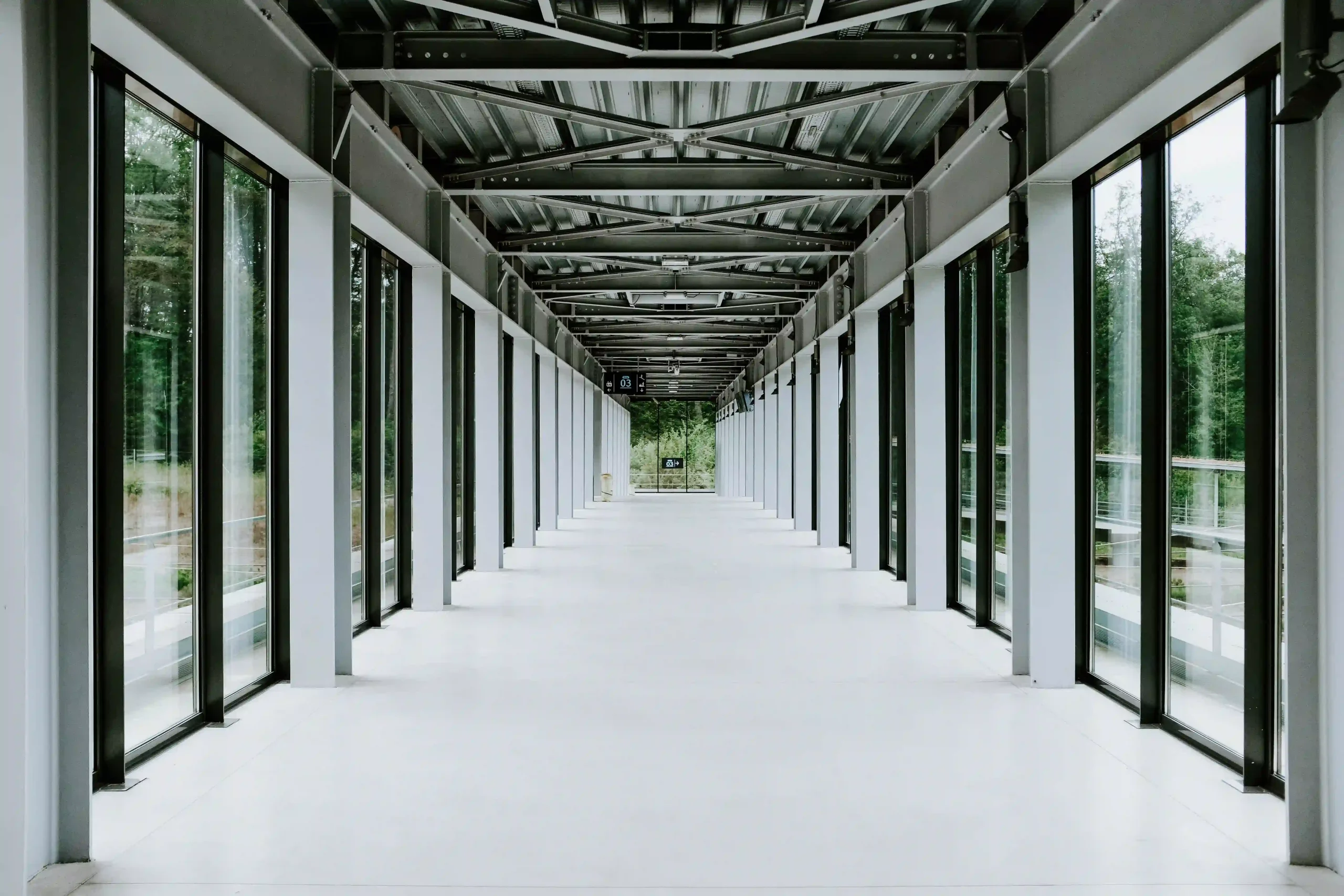 white-hallway-with-glass-doors-metal-ceiling-modern-building